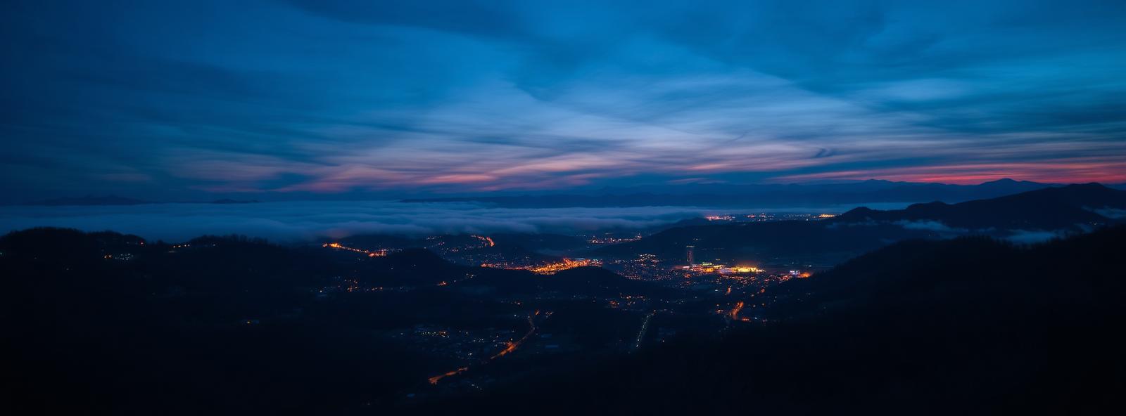 Aerial view of the Asheville, North Carolina skyline at dusk, illustrating the metro area TactStack serves structural steel businesses in