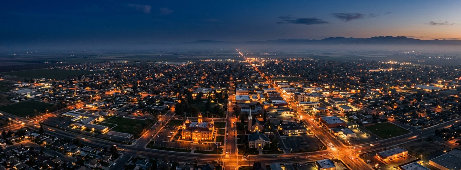 Aerial view of the Hanford, California skyline at dusk, illustrating the metro area TactStack serves structural steel businesses in