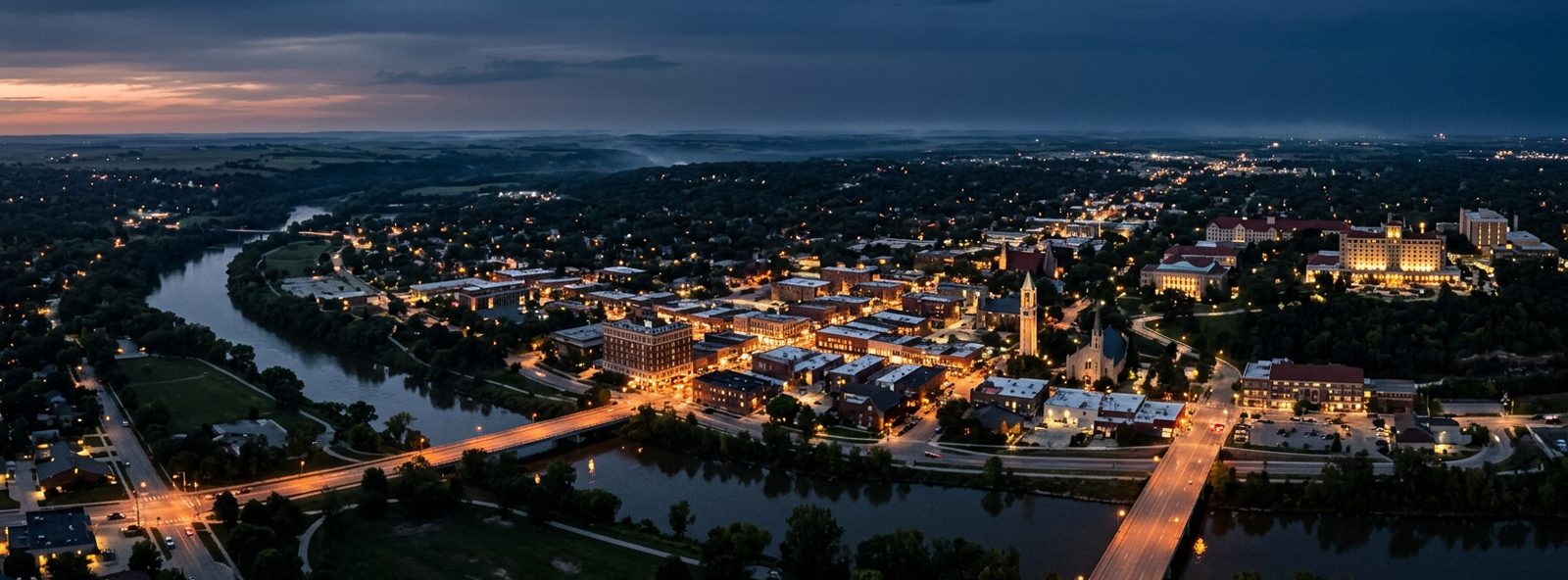 Aerial view of the Lawrence, Kansas skyline at dusk, illustrating the metro area TactStack serves structural steel businesses in
