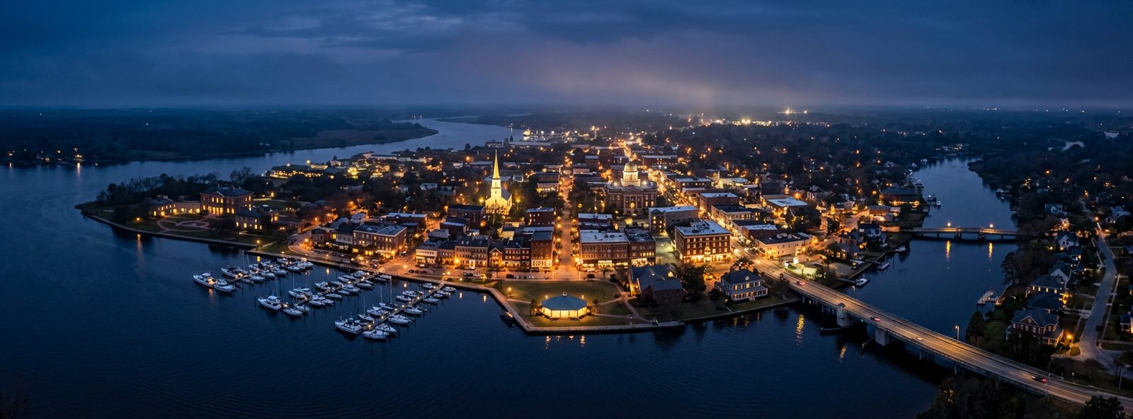 Aerial view of the New Bern, North Carolina skyline at dusk, illustrating the metro area TactStack serves structural steel businesses in
